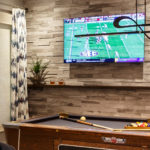 Stone wall behind pool floating shelf light fixture over pool table